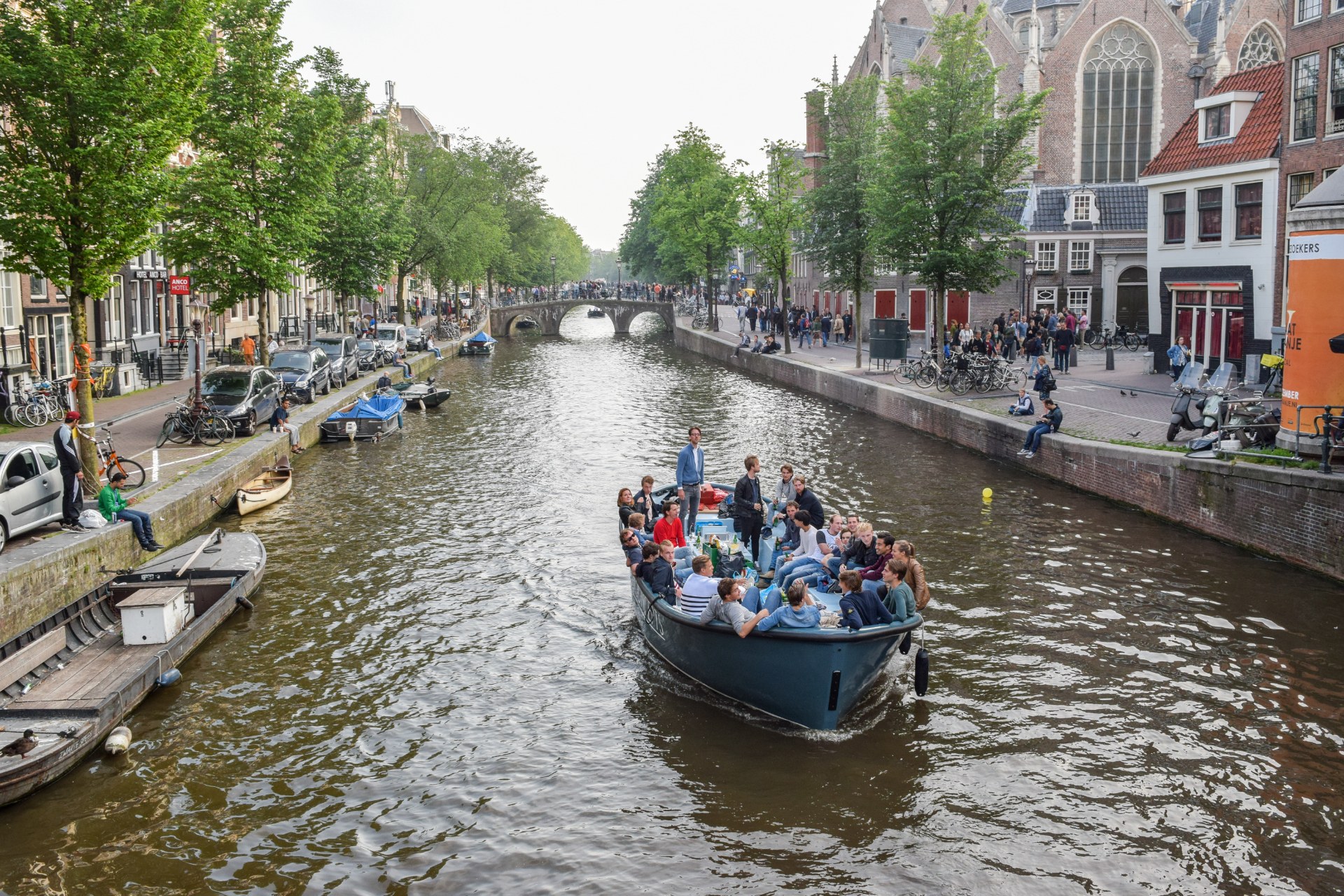 Mladí ľudia na lodi na amsterdamskom kanáli